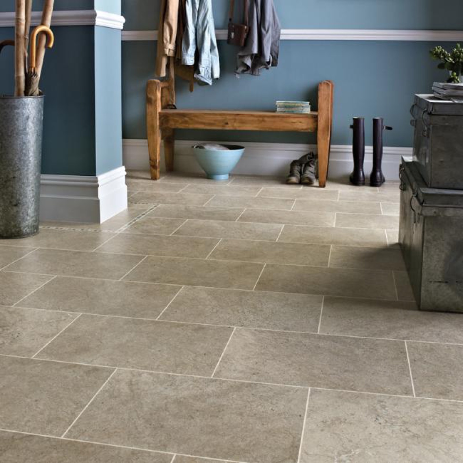 Modern entryway featuring stone tile flooring, wooden bench, and blue walls