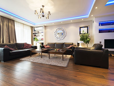 Luxury vinyl plank living room flooring installation. Black leather sofa, loveseat & oversized lounger. Chandelier lighting.